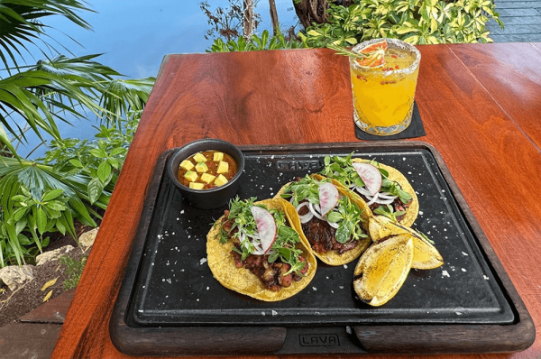 charred tacos plated on table next to mayakoba canals